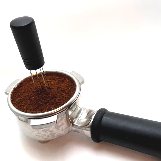 WDT distribution tool with thin needles inserted into espresso grounds to break clumps and even out density.